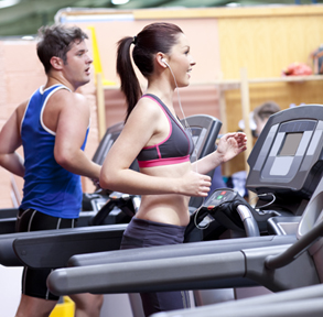 Healthy couple running on a treadmill in a sport centre